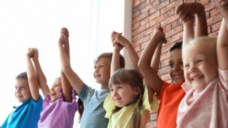 Kleine Kinder halten sich fröhlich an den Händen Kleine Kinder halten sich fröhlich an den Händen