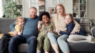 Familienfoto - Pflegeeltern mit ihren Kindern Zuhause